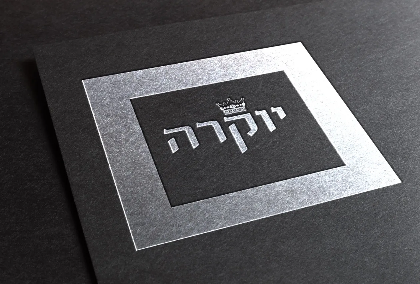 לוגו יוקרה — כיתוב כספי מוטבע על נייר שחור פרימיום